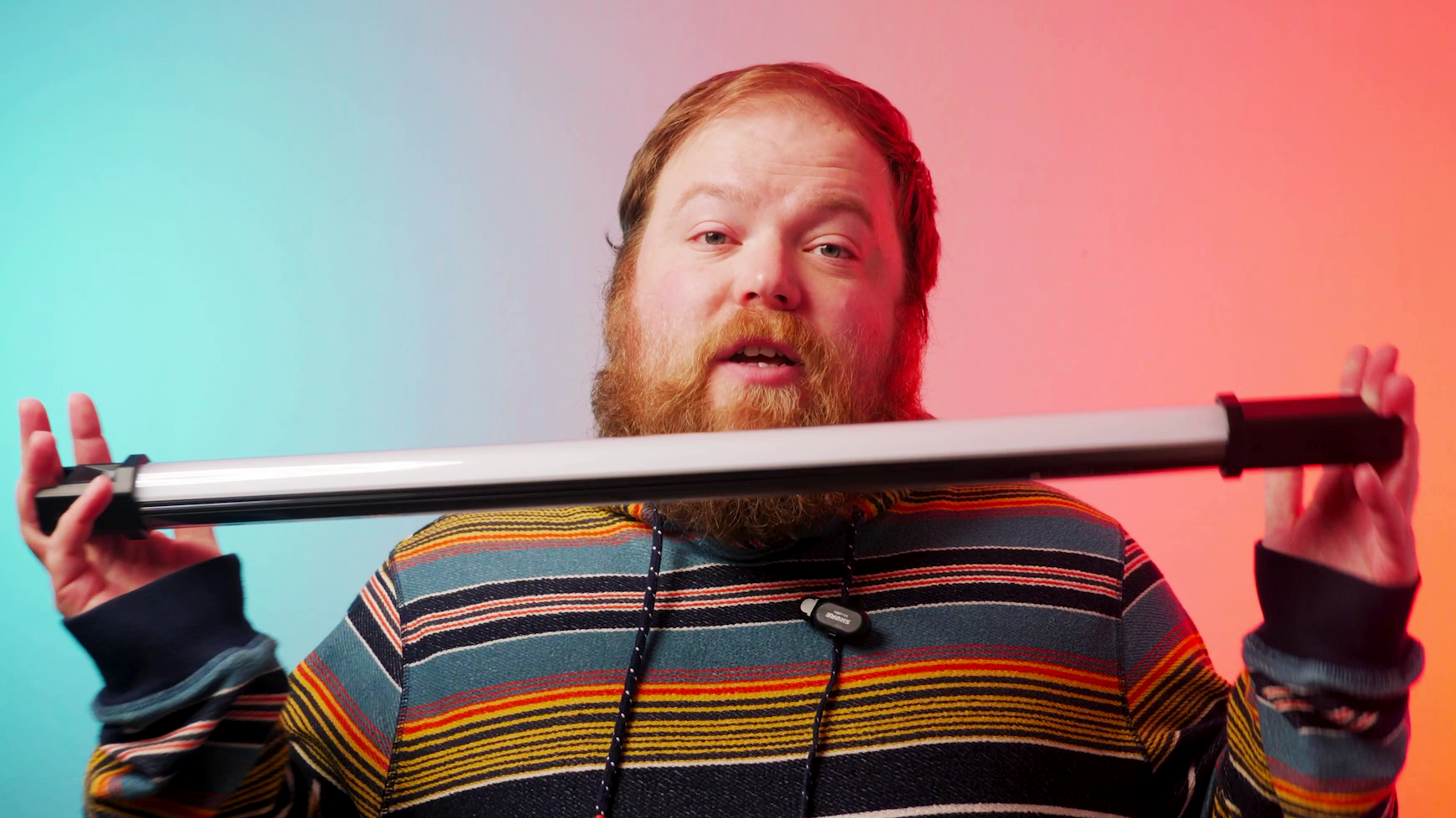 Man holding a light, he is lit with a professional lighting set up